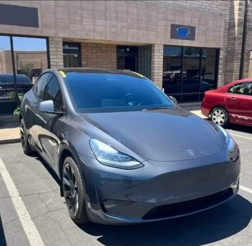 Gray Tesla Model Y with tinted windows parked in front of the Mr. Glassworks Tempe shop