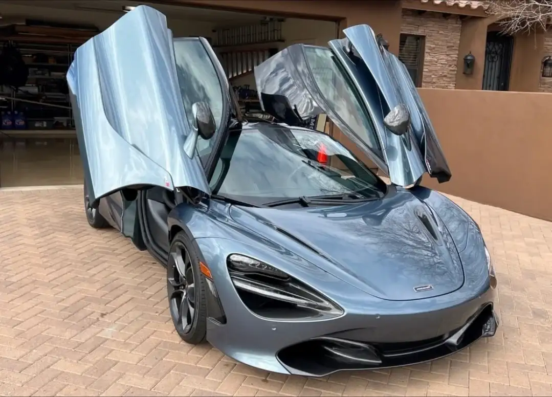 Gray McLaren 720S with dihedral doors open at a customer residence after windshield service