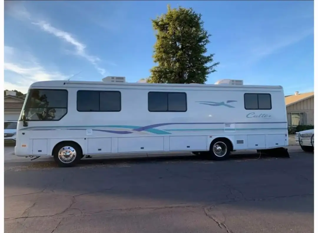 White Class A Cutter motorhome with completed windshield replacement parked at the shop